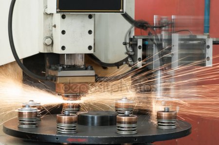 A machine is cutting metal with sparks flying.