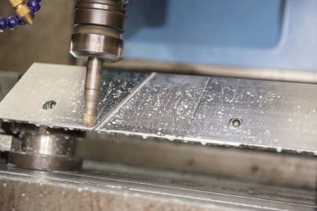 A machine cutting metal with a drill.